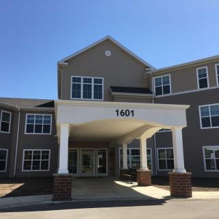 A modern building entrance with a covered entryway and large windows.