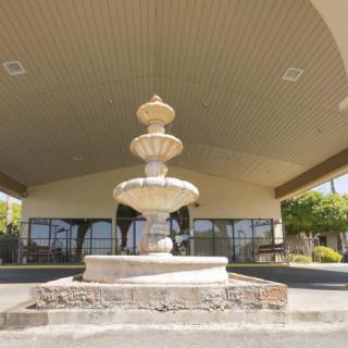 A decorative fountain situated in a covered outdoor area with a paved surface.