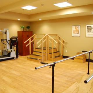 A tranquil rehabilitation room equipped for physical therapy with stairs and ballet bars.