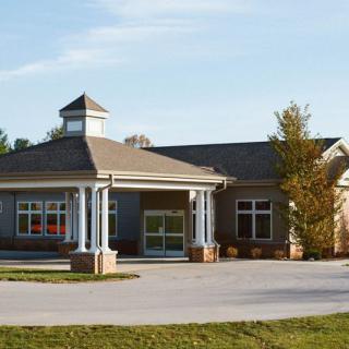 A single-story residential building with a gable roof and columns at the entrance.
