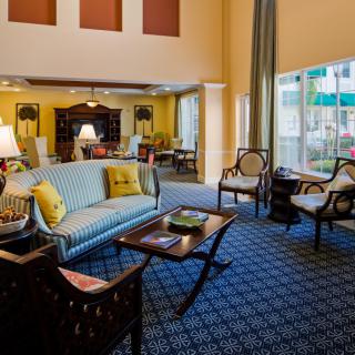 A cozy living room with comfortable seating, elegant furniture, and large windows.