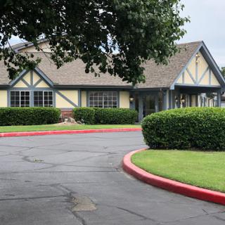 A charming building surrounded by well-maintained landscaping and a curved driveway.