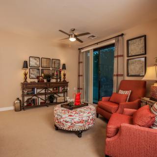 A cozy living room with red armchairs, a patterned coffee table, and elegant decor.