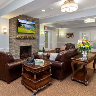 A cozy living room with leather sofas and a fireplace, adorned with elegant decor.
