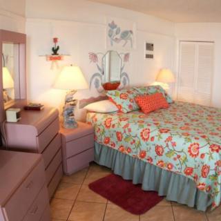 Cozy bedroom with floral bedding and pastel decor.