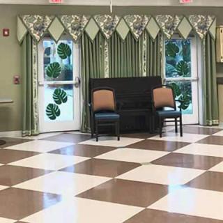 A decorated room with a checkered floor, chairs, and shamrock decorations on the doors.