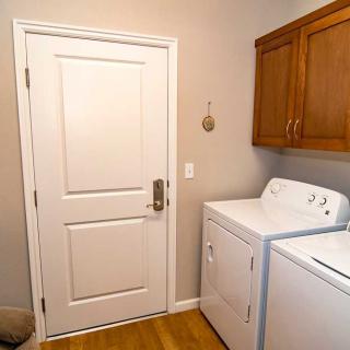 A tidy laundry room featuring a washing machine and dryer beside wooden cabinets.