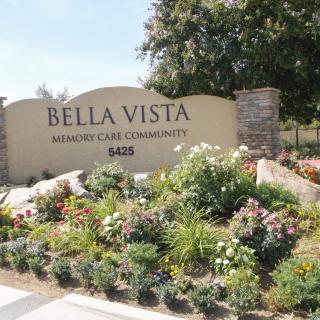 Entrance sign of the Bella Vista community with landscaped gardens.