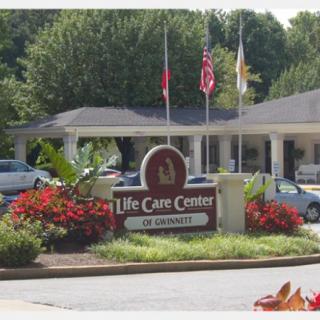 Entrance to Life Care Center with flags and landscaping.