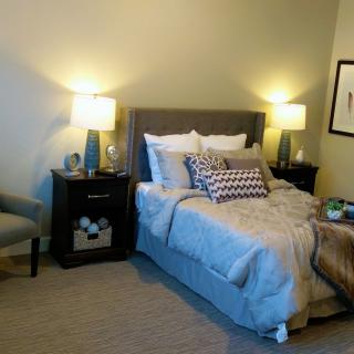 A cozy bedroom with a neatly made bed, two lamps on bedside tables, and tasteful decor.
