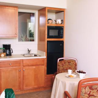 A cozy kitchen area featuring a compact setup with a sink, microwave, and dining space.