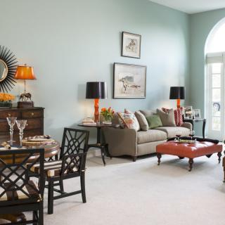 A stylishly decorated living room with a sofa, lamps, and artwork on the walls.