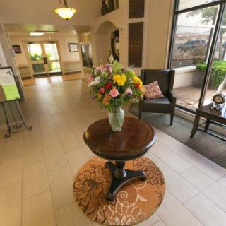 A hotel lobby with a central table displaying a vase of colorful flowers.