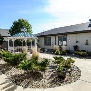 A well-maintained backyard featuring a gazebo, with landscaped greenery and a winding pathway.
