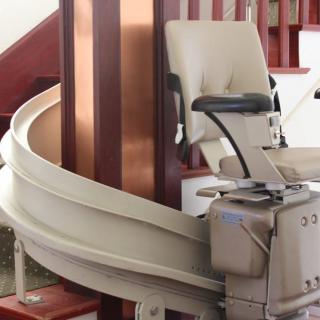 A stairlift with a curved rail installed on a staircase for assisted mobility.