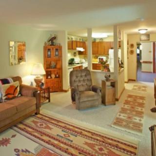 A cozy living room featuring comfortable seating, warm lighting, and decorative rugs.