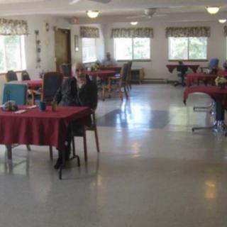A spacious dining hall with red tablecloths on tables and large windows providing ample natural light.
