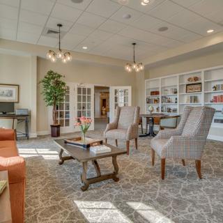 A cozy and well-decorated living room featuring comfortable seating, bookshelves, and soft lighting.