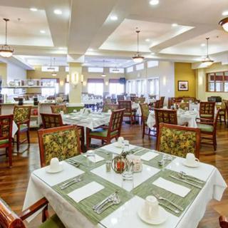 A spacious and elegantly decorated restaurant dining area with neatly arranged tables and chairs.