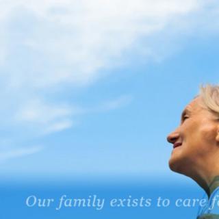 A senior person looking up at the sky with a serene expression, accompanied by the text 'Our family exists to care.'