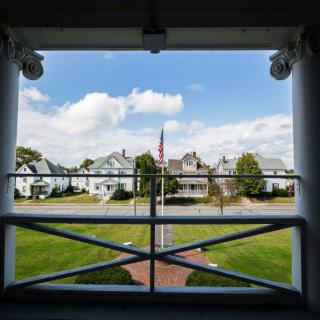 View of residential houses and a green lawn from a patio.