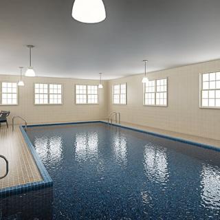 A serene indoor swimming pool with ample lighting and multiple windows.