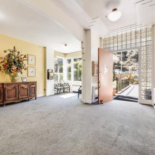A bright and welcoming entrance with natural light streaming through large windows and an open door.