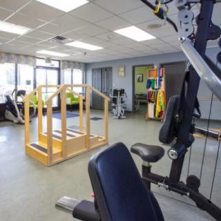 A well-equipped fitness and rehabilitation room with various exercise machines and therapy equipment.
