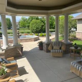 A serene patio with comfortable seating and a view of a lush garden.