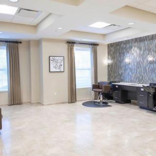 A modern and spacious salon interior with chairs and mirrors.