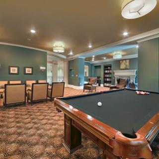 A stylish billiards room featuring a pool table, seating area, and elegant decor.