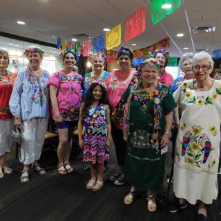 A group of people wearing colorful traditional clothing at a festive indoor gathering.
