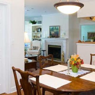 A cozy and inviting dining area with a beautiful table setting, complemented by an adjoining living space featuring a fireplace.