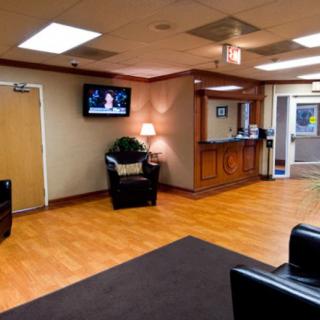 A comfortable waiting room with chairs, a television, and a reception desk.