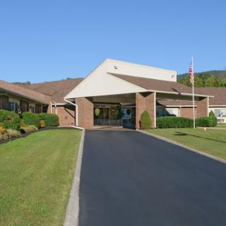 A welcoming entrance to a well-maintained building with landscaping and a flag.