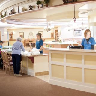 Staff members assisting a visitor at the reception area.