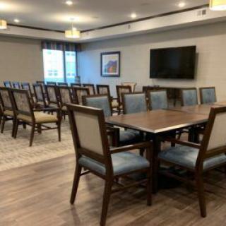A modern conference room with multiple chairs and a television, suitable for meetings.