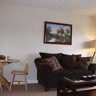 A cozy living room with a sofa, coffee table, and wall artwork.