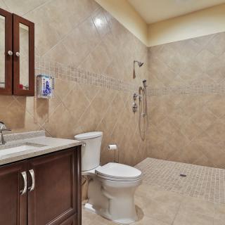 Spacious bathroom with a modern design featuring a walk-in shower and wooden vanity.
