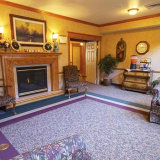 A cozy living room with a traditional design, featuring a fireplace and classic furnishings.