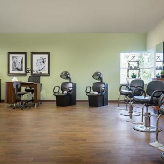 A modern hair salon interior with styling chairs and dryers.