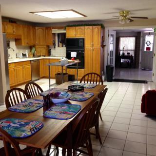 A cozy kitchen and dining area with wooden cabinets and a large table.