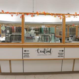 A view of a cafeteria food service counter decorated with autumn-themed elements.