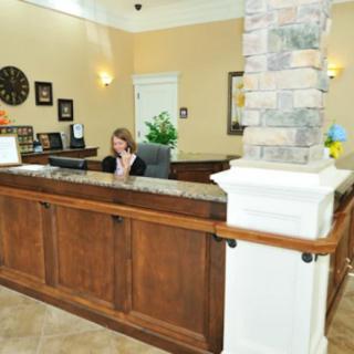 A receptionist working at the front desk in an office lobby.