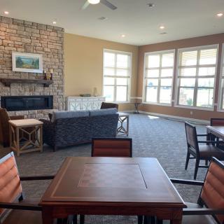 A spacious living room with large windows, comfortable seating, and a fireplace.