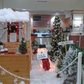 A festive indoor scene lovingly decorated for the holiday season, featuring a snowman, Christmas trees, and cheerful decorations.