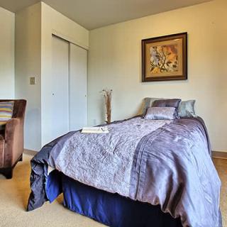 A cozy bedroom with a neatly made bed and wall art.