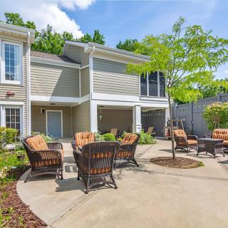 A sunny patio area with outdoor seating in front of a residential building.