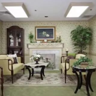 A cozy living room with traditional decor, featuring a fireplace, comfortable seating, and elegant furnishings.