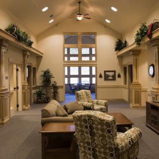 A warmly lit lobby area featuring comfortable seating and decorative plants.